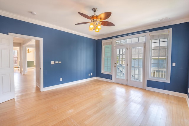 spare room with crown molding, baseboards, ceiling fan, and light wood finished floors