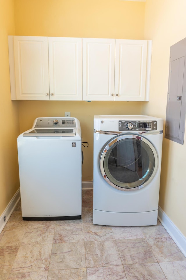 clothes washing area featuring cabinet space, baseboards, washing machine and clothes dryer, and electric panel