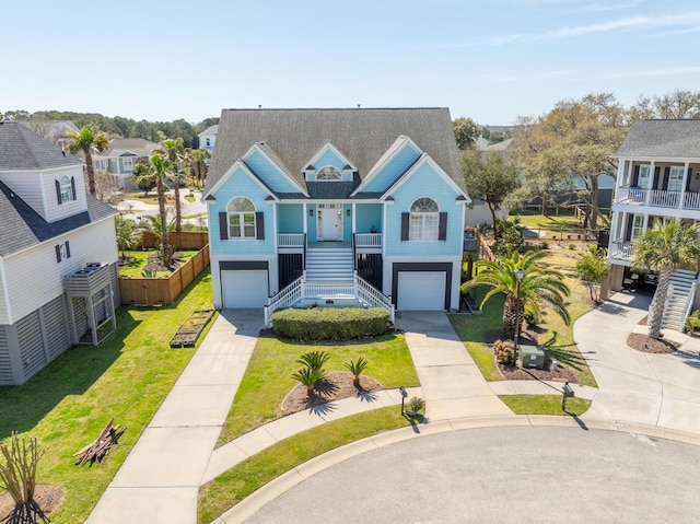 view of front of home with a garage, stairs, driveway, and a front lawn
