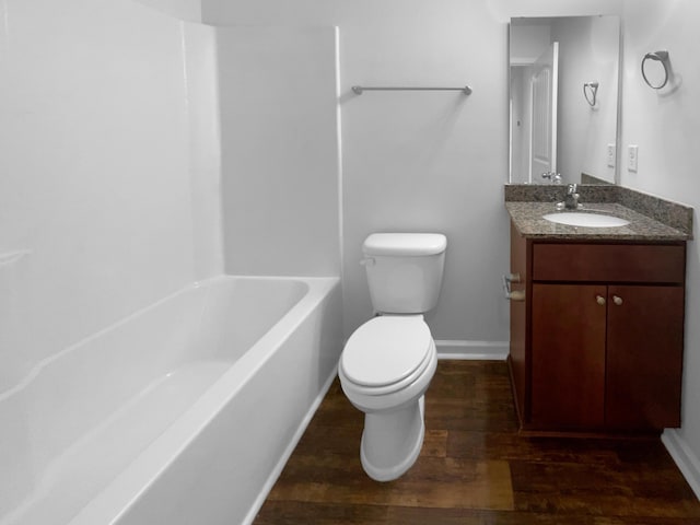 bathroom featuring vanity, toilet, wood finished floors, and baseboards