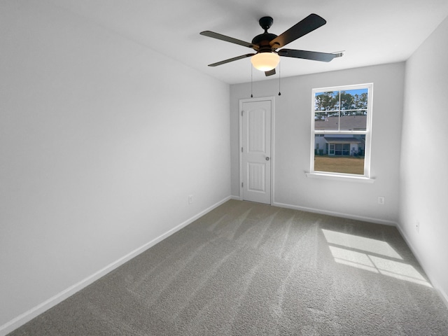 spare room with baseboards, carpet, and ceiling fan