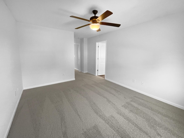 carpeted empty room with ceiling fan and baseboards