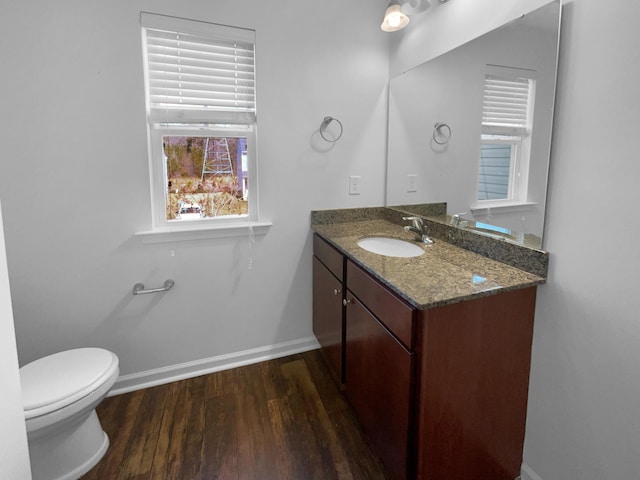 bathroom featuring vanity, toilet, wood finished floors, and baseboards