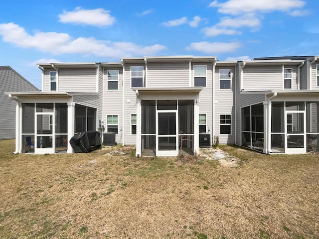 back of property featuring a lawn, central AC, and a sunroom