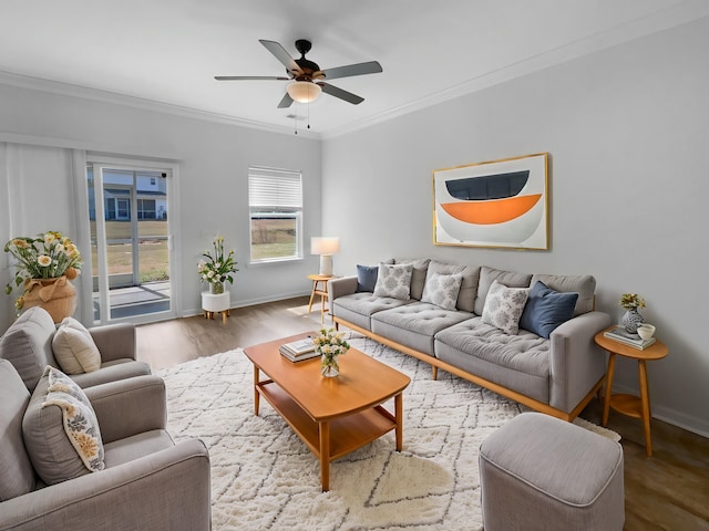 living room featuring ceiling fan, baseboards, wood finished floors, and ornamental molding