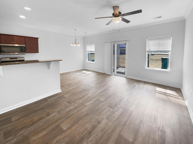 unfurnished living room featuring visible vents, dark wood-style flooring, crown molding, and ceiling fan with notable chandelier