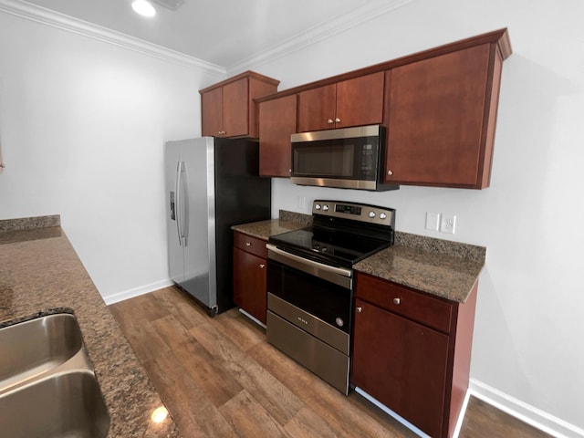 kitchen featuring a sink, crown molding, baseboards, appliances with stainless steel finishes, and dark wood-style flooring