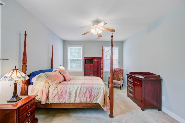 bedroom with light carpet, ceiling fan, and baseboards