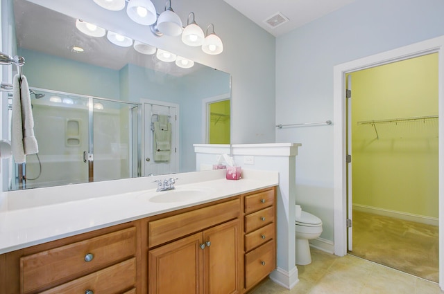 bathroom with visible vents, a spacious closet, toilet, vanity, and a stall shower