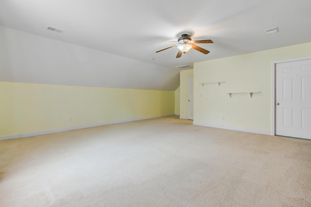 additional living space featuring light colored carpet, baseboards, a ceiling fan, and visible vents