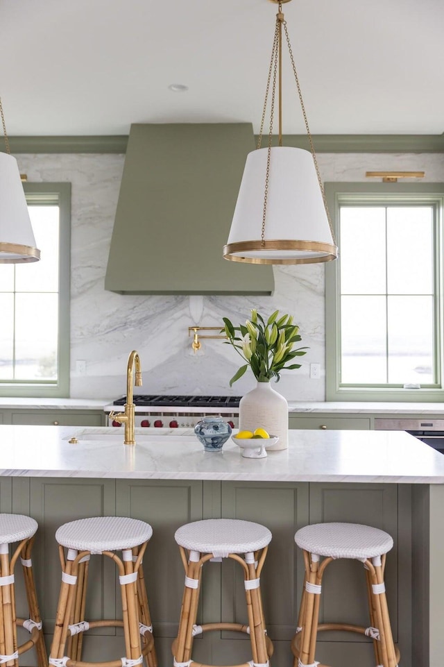 kitchen with a kitchen bar, a healthy amount of sunlight, and hanging light fixtures