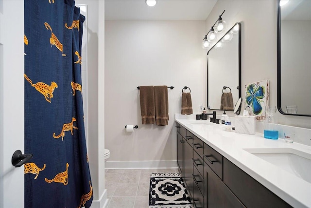 bathroom with tile patterned flooring, baseboards, double vanity, toilet, and curtained shower