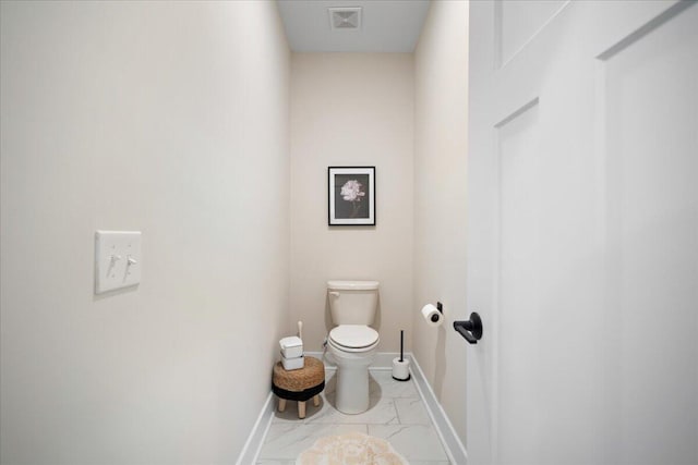 bathroom featuring baseboards, toilet, and marble finish floors