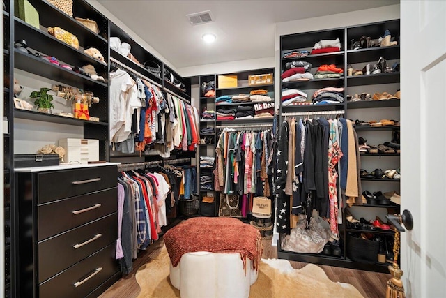 walk in closet with light hardwood / wood-style floors