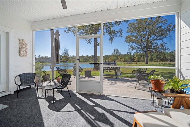 sunroom / solarium featuring a water view