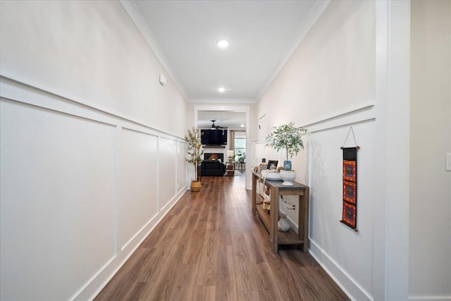 corridor featuring dark wood-type flooring and ornamental molding