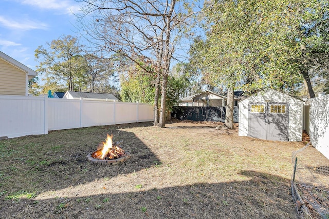 view of yard featuring a storage unit and an outdoor fire pit