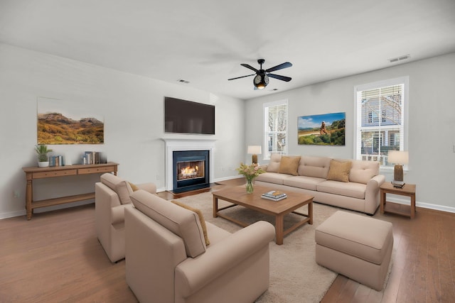 living room with ceiling fan, wood-type flooring, and plenty of natural light