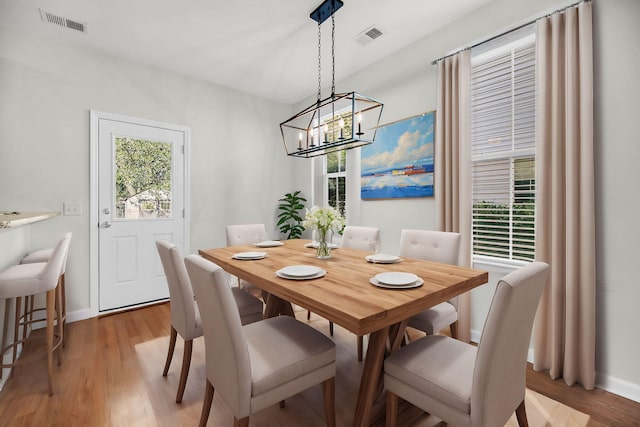 dining area featuring light wood-type flooring and an inviting chandelier