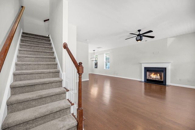 stairs featuring hardwood / wood-style flooring and ceiling fan