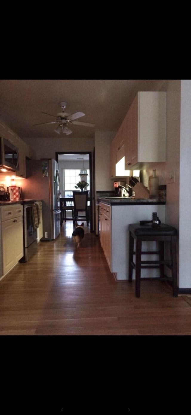 5423 Buckeye Rd, Hollywood, SC 29449 - kitchen featuring black microwave, wood finished floors, dark countertops, freestanding refrigerator, and a ceiling fan