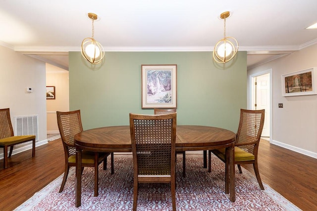 dining area with wood-type flooring and ornamental molding