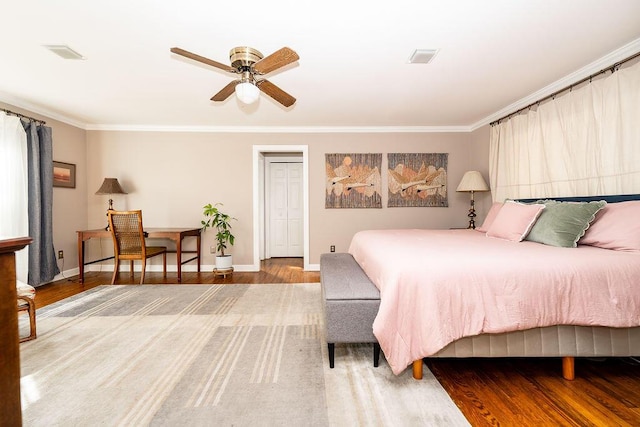 bedroom featuring hardwood / wood-style floors, crown molding, and ceiling fan