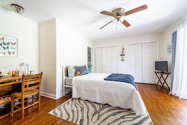 bedroom with multiple closets, crown molding, and dark wood-type flooring