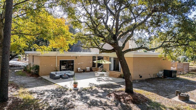 rear view of house featuring central AC, outdoor lounge area, and a patio area