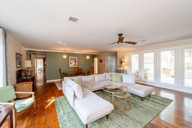 living room with crown molding, ceiling fan, and dark hardwood / wood-style floors