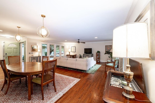 dining space featuring dark wood-type flooring, ornamental molding, and ceiling fan