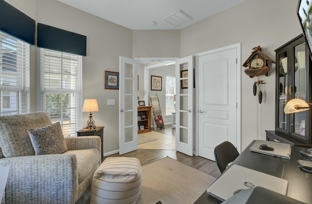 home office featuring hardwood / wood-style floors and french doors