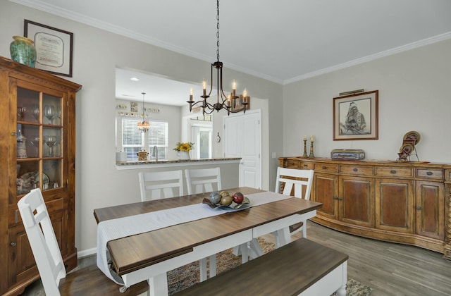 dining area featuring an inviting chandelier, crown molding, and dark hardwood / wood-style floors