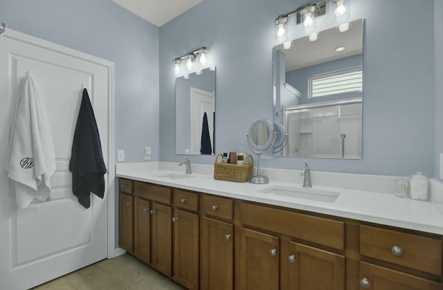 bathroom with a shower with door, vanity, and tile patterned floors