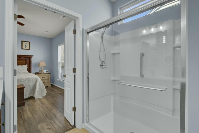 bathroom featuring hardwood / wood-style flooring, an enclosed shower, and ceiling fan