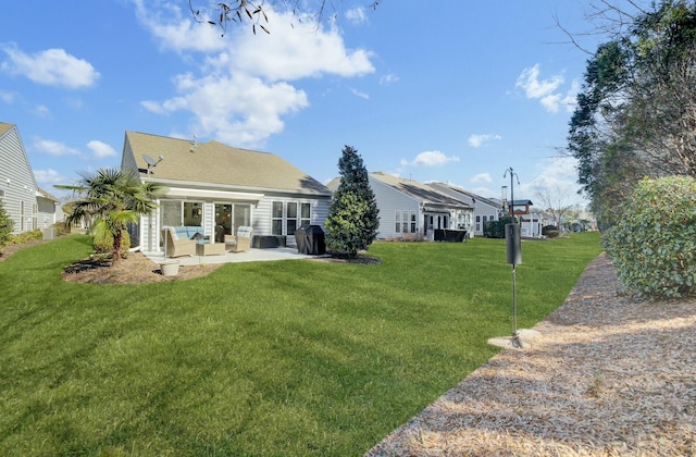 back of house with a yard and a patio