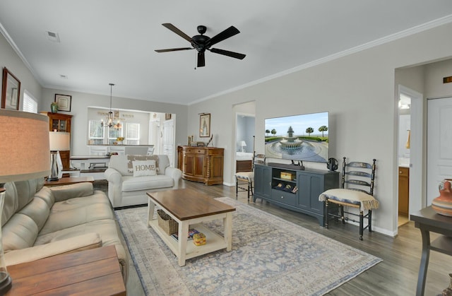 living room with hardwood / wood-style flooring, ornamental molding, and ceiling fan with notable chandelier