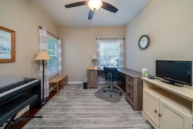 office area with a wealth of natural light, light hardwood / wood-style floors, and ceiling fan