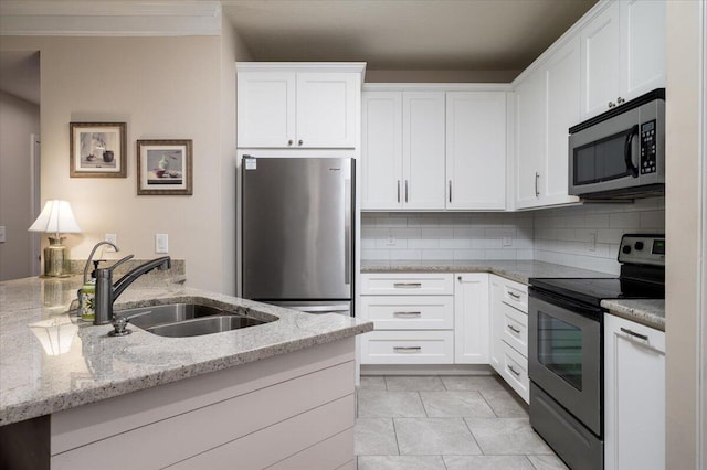 kitchen with light stone countertops, white cabinetry, appliances with stainless steel finishes, and sink