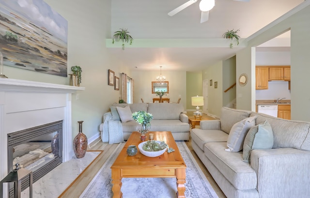 5347 Sundial Ct, North Charleston, SC 29418 - living room featuring light wood-style floors, a chandelier, ceiling fan, baseboards, and a fireplace with flush hearth
