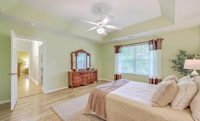 5347 Sundial Ct, North Charleston, SC 29418 - bedroom with light wood-type flooring, baseboards, a tray ceiling, and a ceiling fan