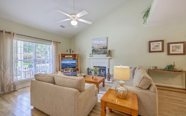 5347 Sundial Ct, North Charleston, SC 29418 - living area with light wood-style flooring, a glass covered fireplace, a ceiling fan, high vaulted ceiling, and baseboards