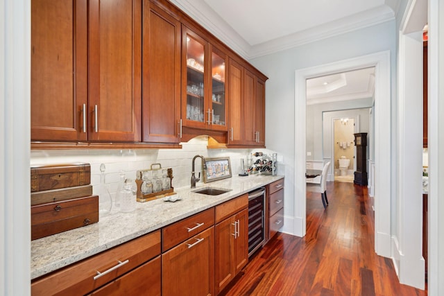 bar featuring decorative backsplash, ornamental molding, dark wood-type flooring, a sink, and beverage cooler