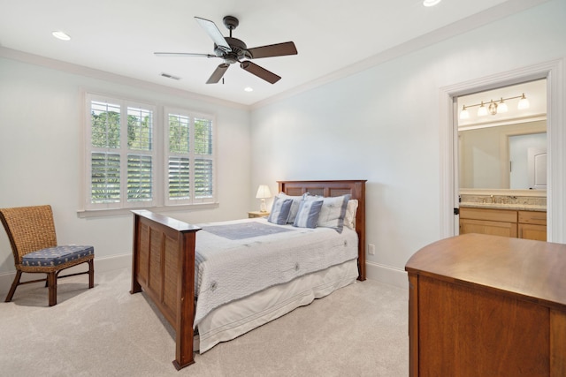 bedroom featuring light colored carpet, visible vents, baseboards, ornamental molding, and ensuite bath