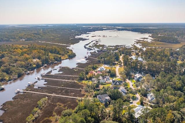 birds eye view of property with a water view and a wooded view