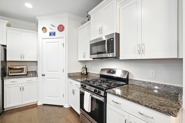2324 Town Woods Rd, Charleston, SC 29414 - kitchen with appliances with stainless steel finishes, white cabinets, crown molding, dark wood-style floors, and dark stone countertops