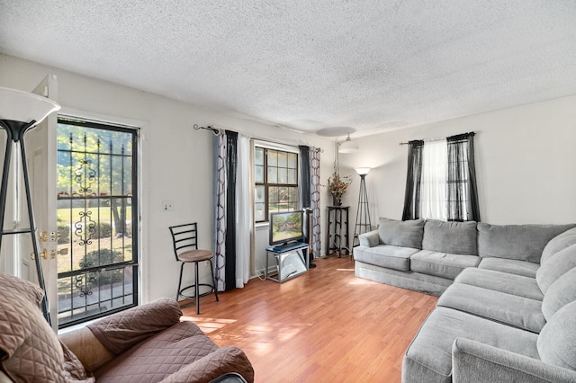 living room featuring light hardwood / wood-style flooring and a textured ceiling