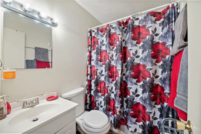 bathroom with vanity, toilet, a textured ceiling, and walk in shower