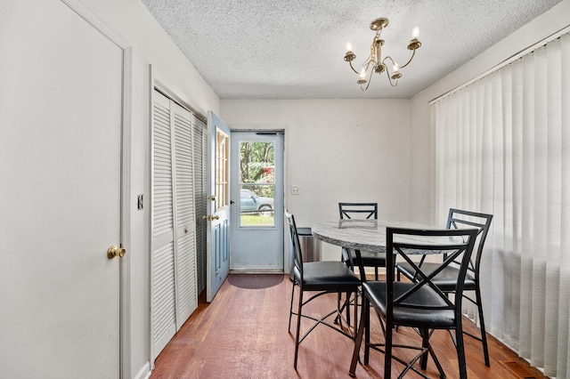 dining area featuring a textured ceiling, a chandelier, and hardwood / wood-style floors