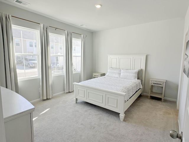 bedroom with light colored carpet, visible vents, and baseboards